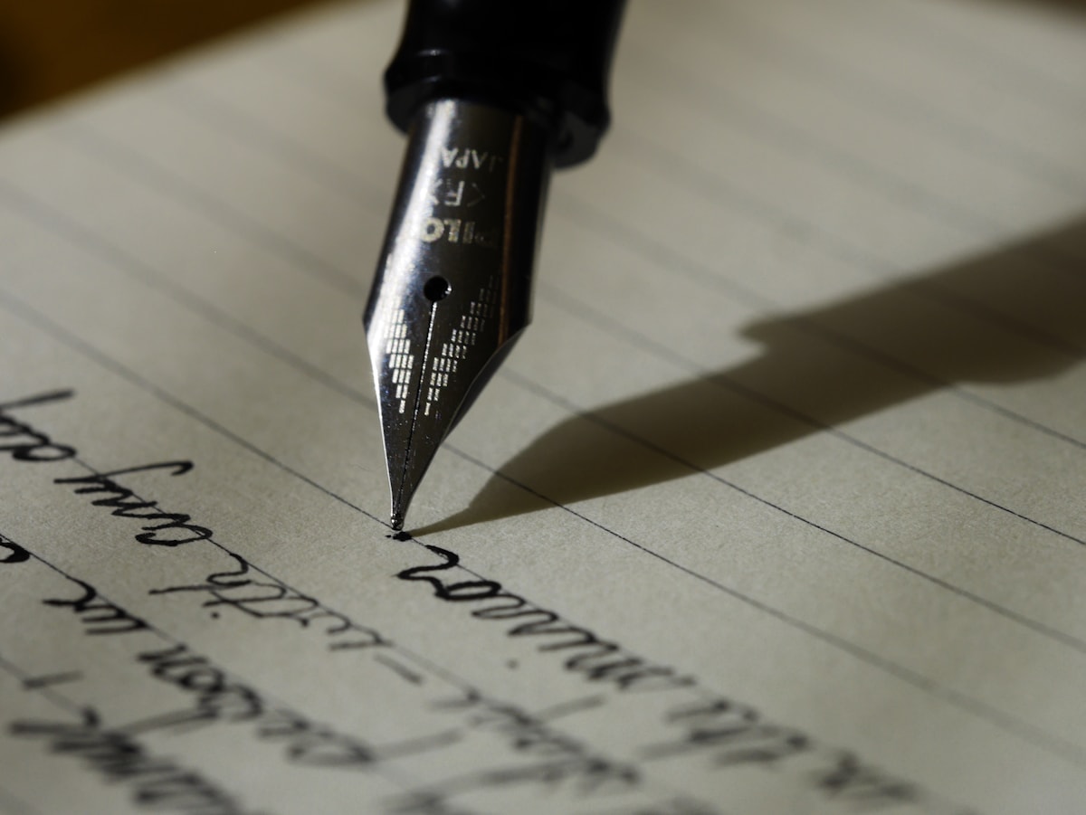Student writing paper instructions in a notebook